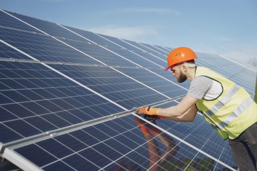 Technician Installing Solar Panel On Commercial Building in Florida