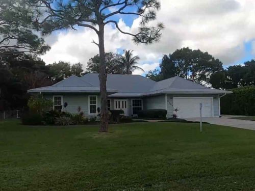 Modern single story home with manicured lawn in the eagles nest neighborhood of jupiter florida
